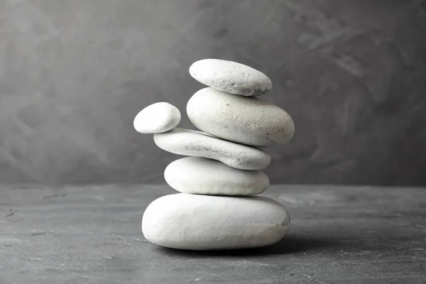 Montón de piedras zen sobre la mesa sobre fondo gris — Foto de Stock
