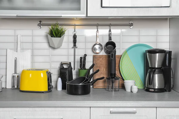 Conjunto de utensilios de cocina, platos limpios y electrodomésticos en el mostrador de cocina — Foto de Stock