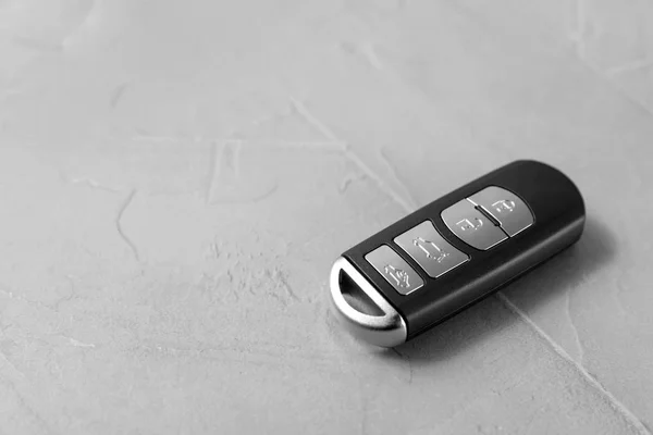 Remote car key on grey background. Space for text