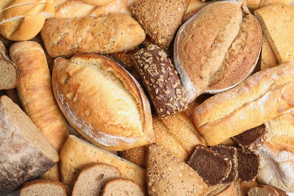 Diferentes tipos de pan como fondo, vista superior — Foto de Stock