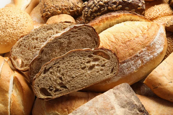 Różne rodzaje chleba jako tło, zbliżenie — Zdjęcie stockowe