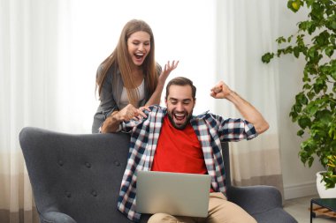 Evde zaferini kutluyor laptop ile duygusal genç Çift