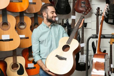 Alıcı modern müzik mağazasında gitar seçimi