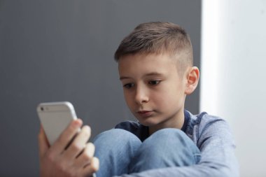 Akıllı telefon oturma kapalı ile üzgün preteen çocuk