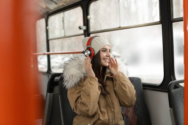 Genç kadın toplu taşıma kulaklıklar ile müzik dinleme