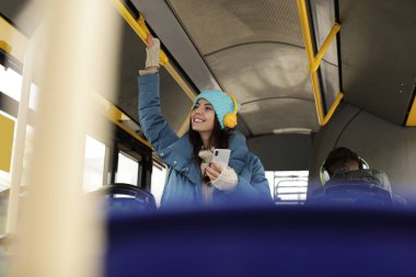 Genç kadın toplu taşıma kulaklıklar ile müzik dinleme