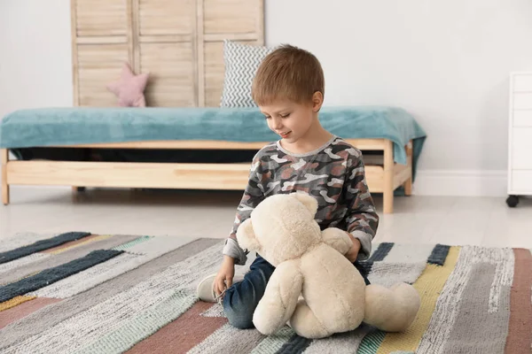 Mignon petit garçon jouer avec ours en peluche à la maison — Photo
