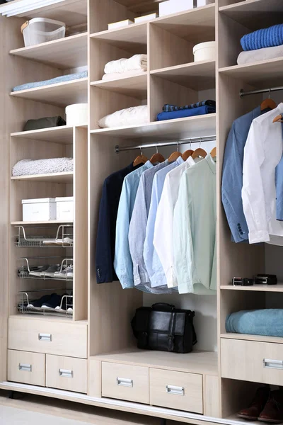 Стильная одежда, обувь и предметы домашнего обихода в большом шкафу — стоковое фото