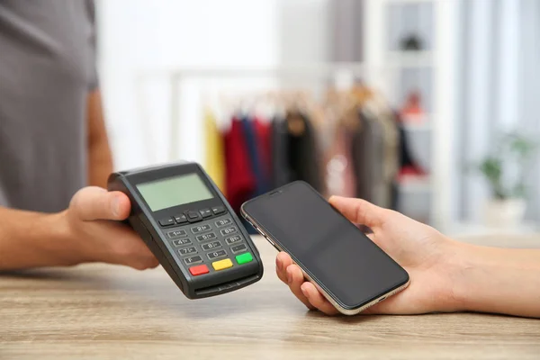 Mujer usando terminal de pago con smartphone en tienda, primer plano. Espacio para texto — Foto de Stock