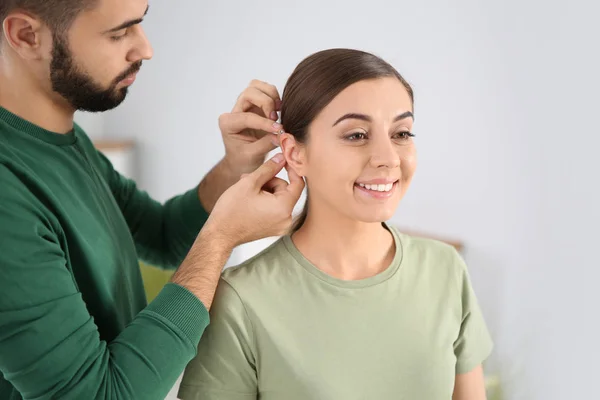 若者女性の耳を屋内に置く補聴器 — ストック写真