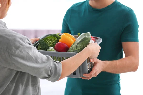 Courrier donnant caisse en plastique avec des produits au client à la maison, gros plan. Service de livraison de nourriture — Photo