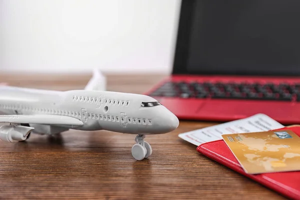 Composição com modelo de avião, passaporte e cartão de crédito em mesa de madeira. Conceito de agência de viagens — Fotografia de Stock
