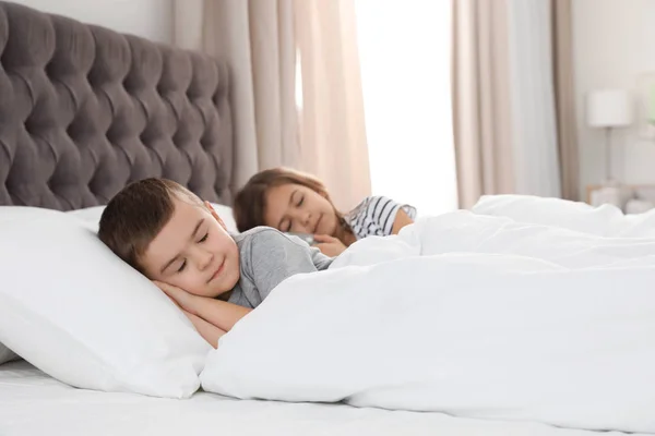 Milé malé děti spící v pohodlná postel — Stock fotografie