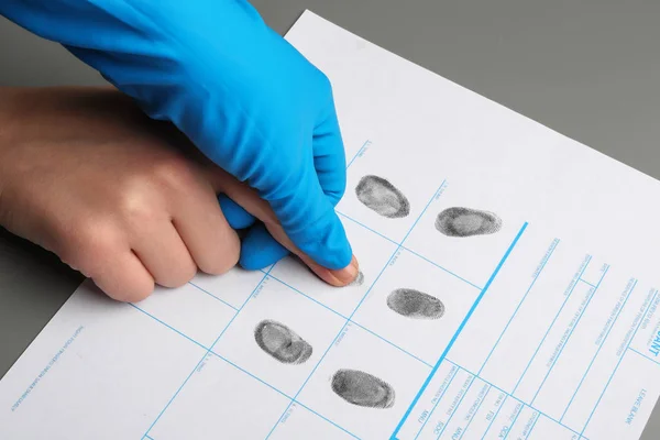 Onderzoeker voor het nemen van vingerafdrukken van verdachte aan tafel, close-up. Criminele expertise — Stockfoto