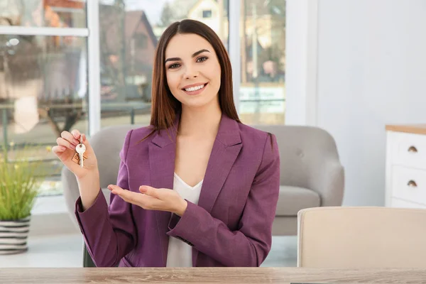 Jeune femme tenant une nouvelle clé de maison à l'intérieur — Photo