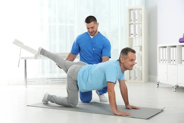 Doctor working with patient in hospital. Rehabilitation exercises — Stock Photo, Image