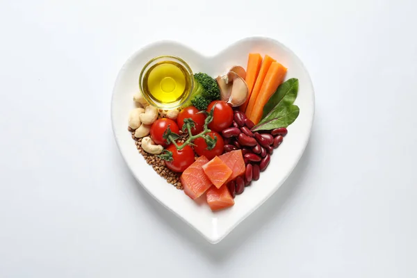Plate with products for heart-healthy diet on white background, top view — Stock Photo, Image