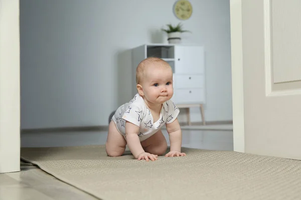 Lindo bebé arrastrándose en la alfombra en el interior — Foto de Stock