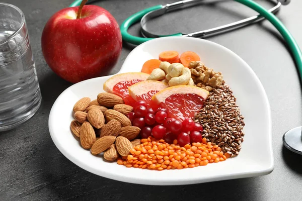 Assiette avec produits pour une alimentation saine pour le cœur sur table grise — Photo