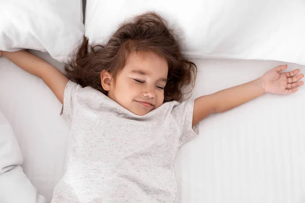 Roztomilá holčička, která spí na útulné posteli, pohled shora — Stock fotografie
