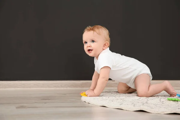 Lindo bebé arrastrándose en la alfombra en el interior, espacio para el texto — Foto de Stock