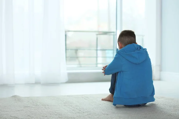 Aufgebrachter Junge, der in der Nähe des Fensters sitzt. Raum für Text — Stockfoto