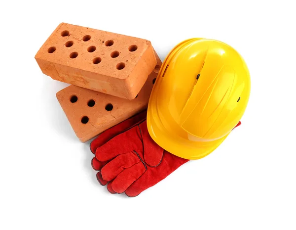 Hard hat, gloves and bricks on white background, top view. Construction industry — Stockfoto