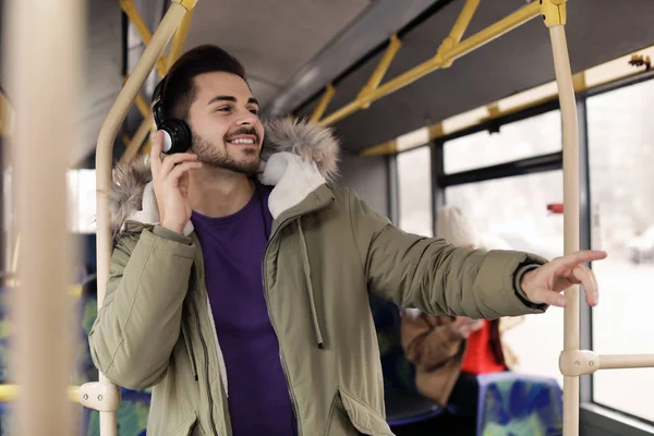 Ung man lyssnar på musik med hörlurar i kollektivtrafiken — Stockfoto