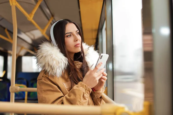 Mujer joven escuchando música con auriculares en el transporte público — Foto de Stock