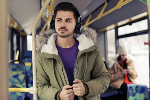 Jovem ouvindo música com fones de ouvido em transportes públicos — Fotografia de Stock