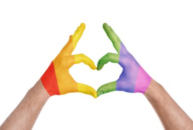 Adam beyaz arka planda LGBT bayrağı boyalı elleri ile kalp yapma, closeup. Gay topluluk  