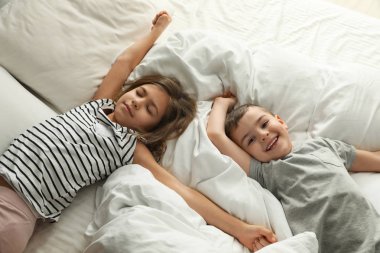 Yatakta sevimli küçük çocuklar, görünüm yukarıda. Sağlıklı uyku