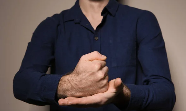 Hombre mostrando palabra CRUCIFÍA en lenguaje de señas sobre fondo de color, primer plano — Foto de Stock