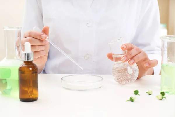 Dermatologista feminino criando produto de cuidados da pele na mesa, close-up — Fotografia de Stock