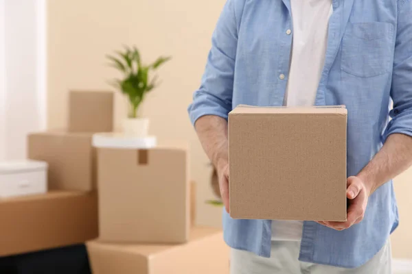 Hombre sosteniendo la caja de mudanza en la nueva oficina, primer plano. Espacio para texto — Foto de Stock