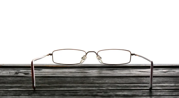 Gafas sobre mesa de madera sobre fondo blanco. Consulta al oftalmólogo —  Fotos de Stock