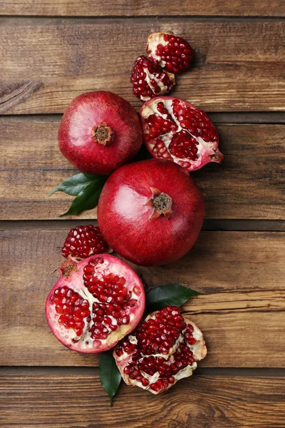 Flat lay composition with ripe pomegranates on wooden background — Stock Photo, Image