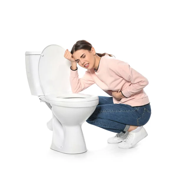 Wanita muda yang menderita mual dekat toilet mangkuk terisolasi di atas putih — Stok Foto