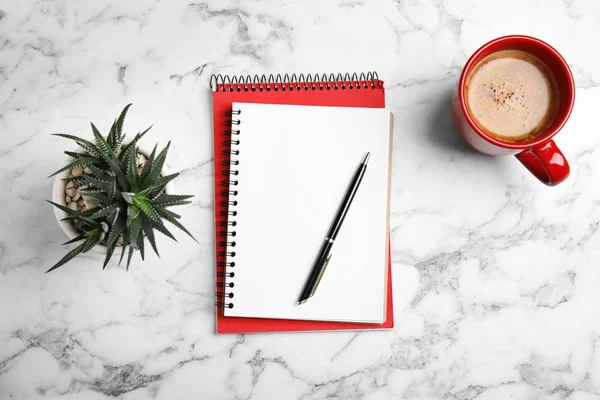 Flat lay composition with notebooks and coffee on marble background