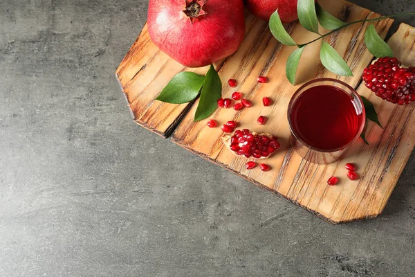 Styrelse med glas granat äpple juice och färsk frukt på grå bakgrund, uppifrån. Utrymme för text — Stockfoto