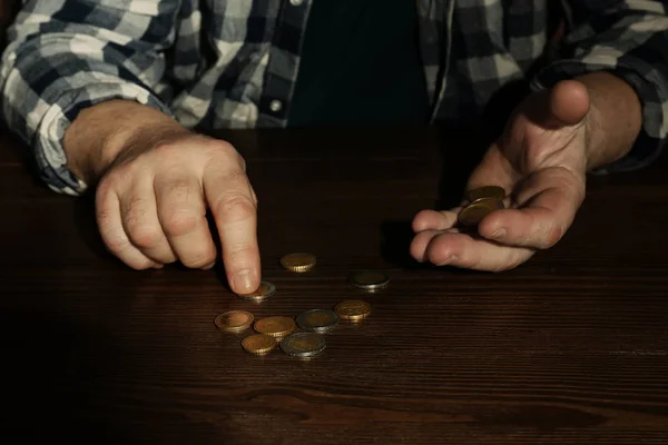 Pobre hombre mayor contando monedas en la mesa, primer plano — Foto de Stock