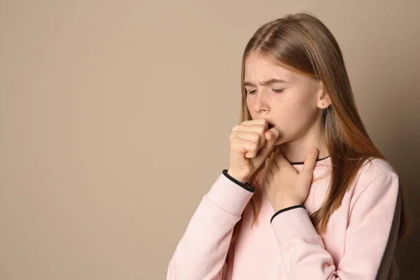 Tonårig flicka som lider av hosta på färgbakgrund. Utrymme för text — Stockfoto