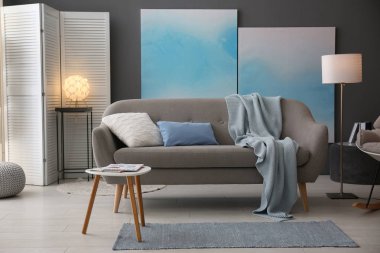 Modern oturma odasının içi rahat kanepeyle dolu.