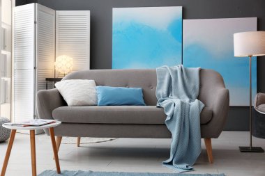 Modern oturma odasının içi rahat kanepeyle dolu.