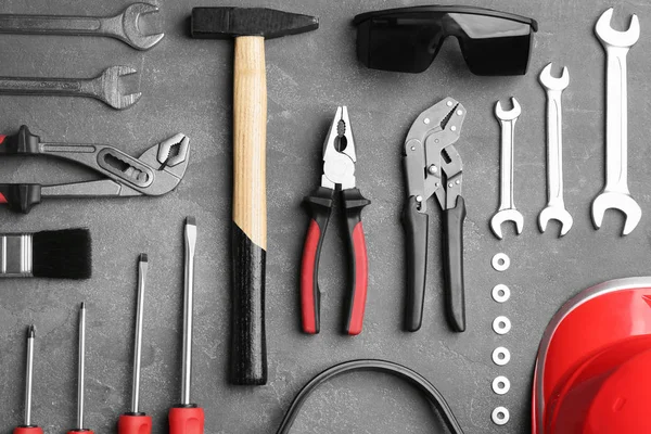 Composición plana con diferentes herramientas de construcción sobre fondo gris —  Fotos de Stock