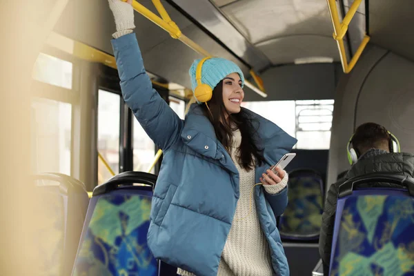 Mujer joven escuchando música con auriculares en el transporte público —  Fotos de Stock