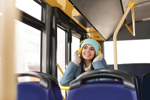 Молодая женщина слушает музыку с наушниками в общественном транспорте — стоковое фото