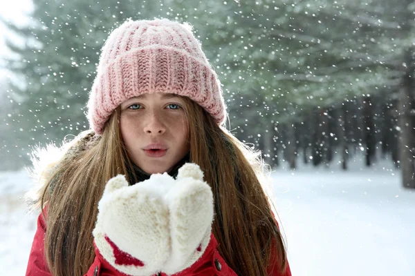 Adolescente soufflant de la neige dans la forêt d'hiver. Espace pour le texte — Photo