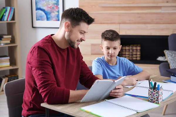 Papá ayudando a su hijo con la tarea en la habitación — Foto de Stock