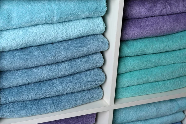 Πολύχρωμες πετσέτες στα ράφια, κοντινά πλάνα. Προμήθειες μπάνιου — Φωτογραφία Αρχείου
